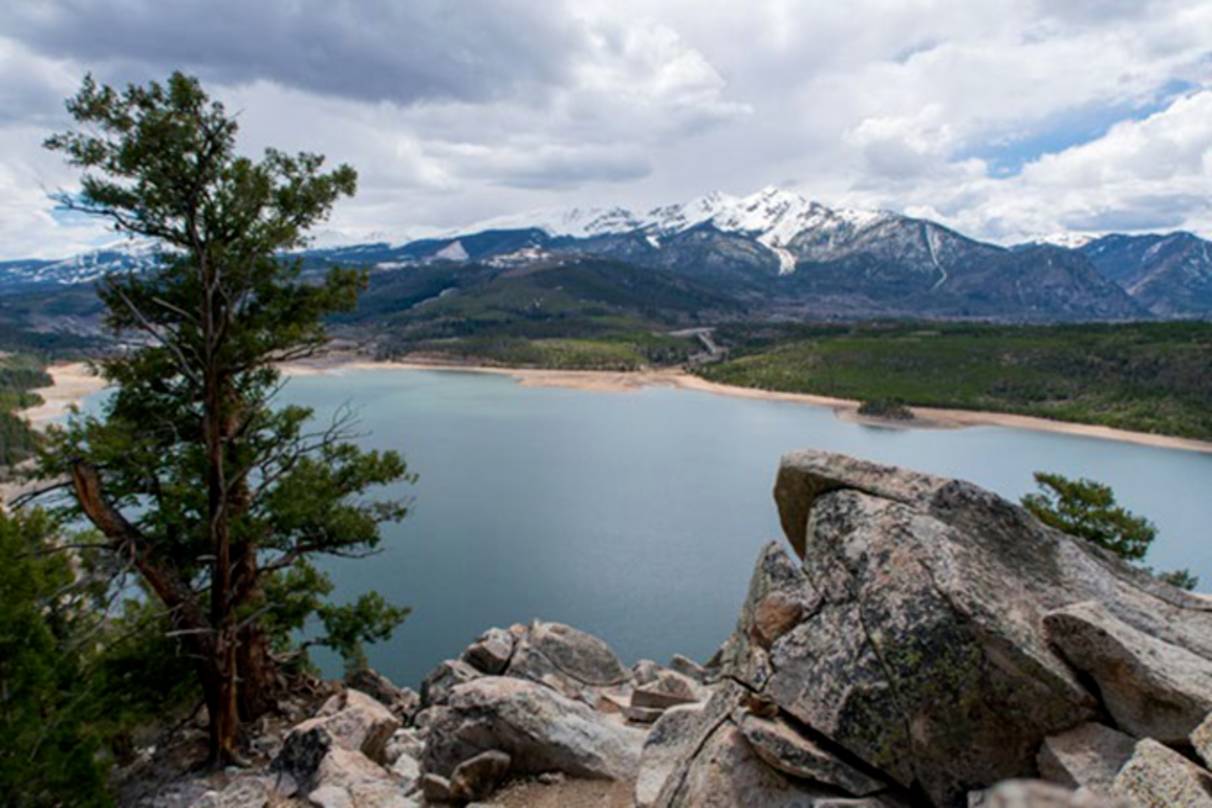 photo of a lake at the base of a large snow capped mountain